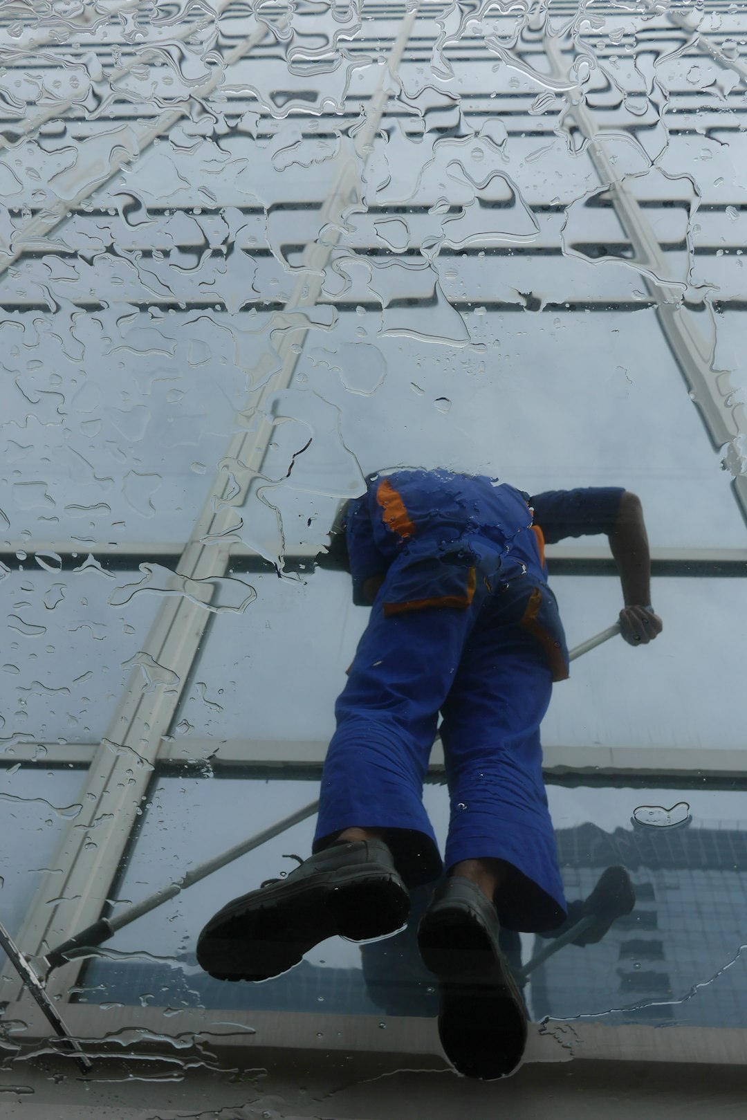 window-cleaner-working-on-a-glass-building-exterior-s6lojzu69s4